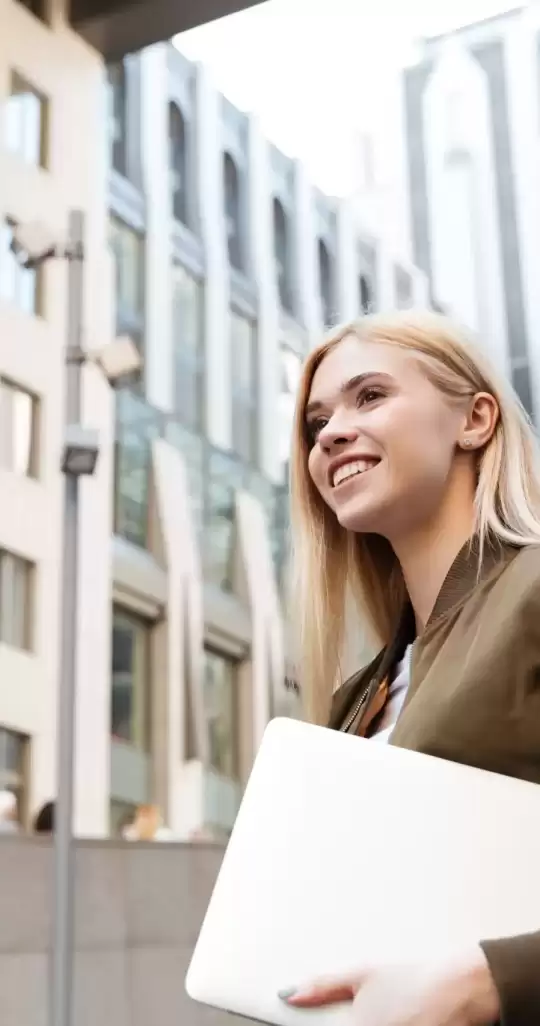 young-woman-with-laptop-computer-walking-street